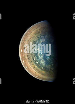 This image of Jupiter's swirling south polar region was captured by NASA's Juno spacecraft as it neared completion of its tenth close flyby of the gas giant planet. The 'empty' space above and below Jupiter in this color-enhanced image can trick the mind, causing the viewer to perceive our solar system's largest planet as less colossal than it is. In reality, Jupiter is wide enough to fit 11 Earths across its clouded disk. The spacecraft captured this image on December 16, 2017, when the spacecraft was about 64,899 miles (104,446 kilometers) from the tops of the clouds of the planet at a latit