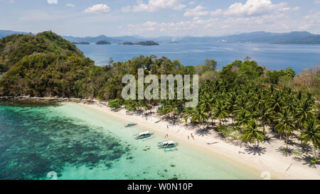 Aerial view of a paradisiacal island with some traditional filipino boats in Palawan, The Philippines, Stock Photo