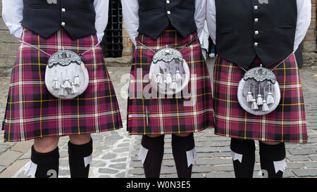 Detail of three men wearing tartan  kilts with sporrans. Stock Photo