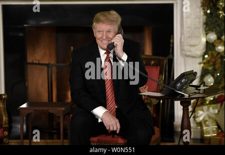 US President Donald Trump participates in NORAD Santa Tracker phone calls in the State Dining Room of the White House in Washington, D.C on December 24, 2018.        Photo by Olivier Douliery/UPI Stock Photo