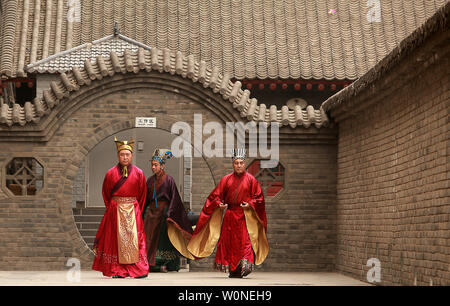 Chinese actors dressed in Tang Dynasty imperial garb walks to an outdoor stage inside the ancient Chinese walled city Xi'an, one of the oldest cities in China and the capital of Shaanxi Province on June 26, 2012.  Xi'an is one of the Four Great Ancient Capitals of China, having maintained the position under several of the most important Chinese dynasties. It is the most complete walled city that has survived in China.    UPI/Stephen Shaver Stock Photo