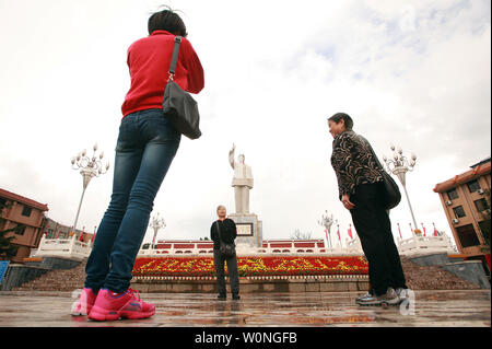Chinese tourists take pictures in front of one of the few remaining public statutes of the late helmsman Mao Zedong in a square in Lijiang, northern Yunnan Province, on September 29, 2012.    During the Cultural Revolution under the Red Guard, Mao's already glorified image manifested into a personality cult that influenced every aspect of Chinese life, and still persists to across the country.    UPI/Stephen Shaver Stock Photo
