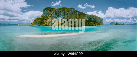 Palawan, Philippines. Aerial drone panoramic view of sandbar with lonely tourist boat in turquoise coastal shallow waters and coral reef in El Nido Stock Photo