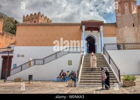 Chefchaouen, Morocco - May 03, 2019: An old Moroccan man goes down the stairs of the Great Mosque after the prayer, in Chefchaouen, (or Chaouen), a ve Stock Photo