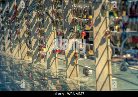 locks with a heart and a lot of other locks on the bridge with reflection. sign of everlasting love. Stock Photo