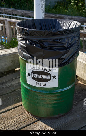 trash can consisting of large green metal drum lined with black plastic with sign saying Help Keep Provincetown Clean Stock Photo