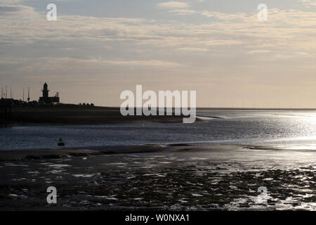 View from Knott End across River Wyre estuary to Fleetwood and to Morecambe Bay with evening light reflecting off water in June, wind farm on horizon. Stock Photo