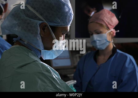 doctors and nurses preforming surgery Stock Photo