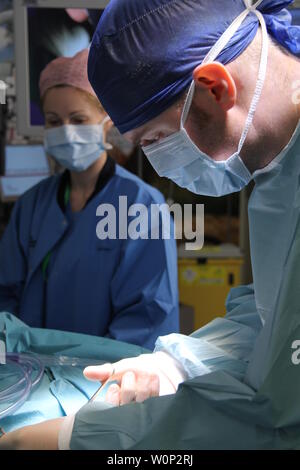 doctors and nurses preforming surgery Stock Photo