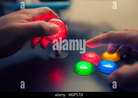 Arcade game machine with huge 45mm red ball top joystick and lighted four button layout. Stock Photo