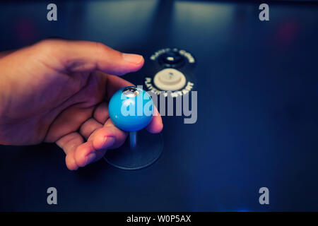 Hands of a video gamer holding a classic 4 way joystick with custom top fire modification and arcade buttons. Stock Photo