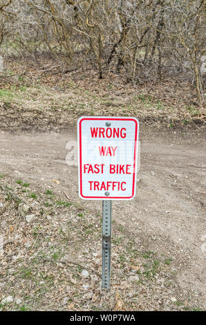 Red and white sign to warn hikers and others about the fast bikes on this trail. Stock Photo