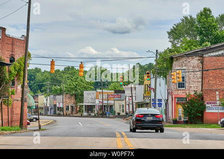 A single car driving on the main street of a small town in rural America, Goodwater Alabama, USA. Stock Photo