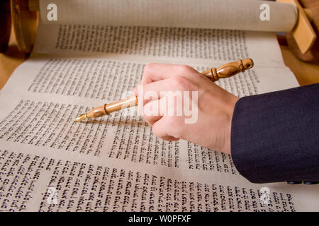 hand pointing at Hebrew writing in scripture Stock Photo