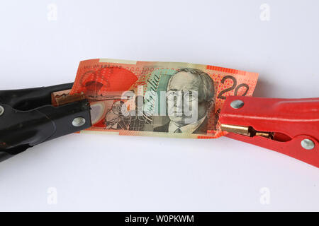 Australian twenty 20 dollar note held by jumper lead clamps. Creative concept for relieve revive money, banking, financial, economic, currency pain Stock Photo