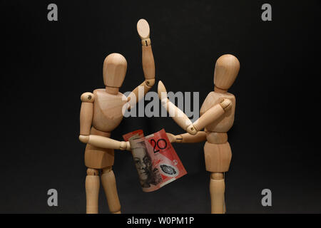 Couple wooden mannequins arguing fighting over mortgage finances financial pressure strain hardship. Australian twenty dollar note. Economic concept Stock Photo