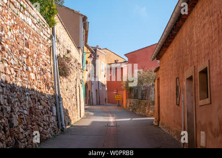 Roussillon, France - January 22, 2019: Houses and buildings facade with the ochre color with clean blue sky as background Stock Photo