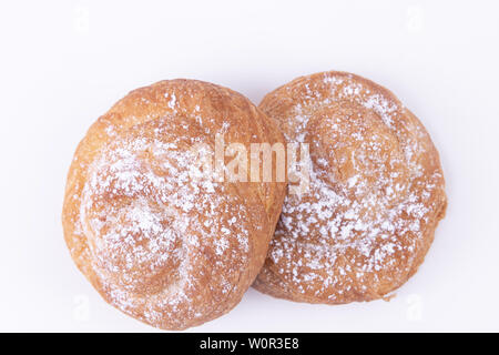 Top view of two freshly baked puff pastries with powdered sugar on top on a white background Stock Photo