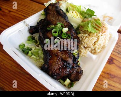 Steak with Salad and brown rice on a to go Styrofoam plate on a wood table. Stock Photo