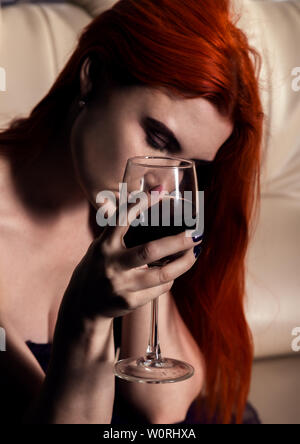upset young woman in depression, holding two glasses with wine. on a dating, waiting for a guy. Stock Photo