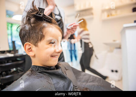 Child little boy in the barber shop hair cut professional smiling portrait looking at mirror - Little boy in the barber shop hair cut professional tod Stock Photo