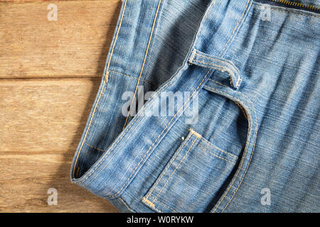 jeans stacked on a wooden background Stock Photo