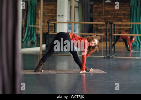 woman stretching in Parsvottanasana or intense side stretch pose at yoga studio Stock Photo