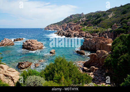 Red rock formation at a beach at Costa Paradiso in Sardinia (Italy) with turquoise and emerald green sea Stock Photo