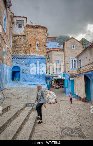 Chefchaouen, Morocco - May 4, 2019: A young woman walking on a nice street in Chefchaouen, Morocco. Stock Photo