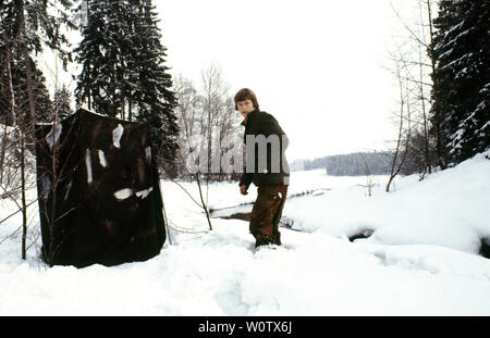 Outdoor photographer Øyvind Martinsen, 16 years old at that time, outside his homemade blind beside the rider Svinna in Våler kommune, Østfold, Norway. The river is a part of the water system called Morsavassdraget. February, 1981. Stock Photo