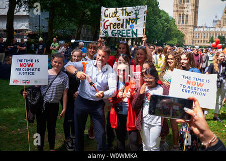 Steve Backshall, naturalist and Bafta Winning t.v. presenter, writer, best known for the 'Deadly 60' BBC television series joins a group of youth for Christian Aid at Global Strike For Climate in Victoria Tower Gardens near Houses of Parliament. Christian Aid is the official relief and development agency of 41 British and Irish churches working to stop poverty and provides disaster relief in developing countries. The event was organised by CAFOD, the Catholic Agency For Overseas Development. Placards bearing the slogan 'The Time Is Now' and 'Cut the Greed, not green' were carried by the group. Stock Photo