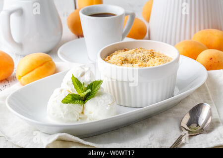 Bowl with apricot crisp crumb and ice cream on table Stock Photo