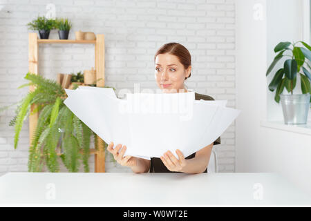 Female office workers holding are arranging documents of unfinished documents on office desk Stock Photo