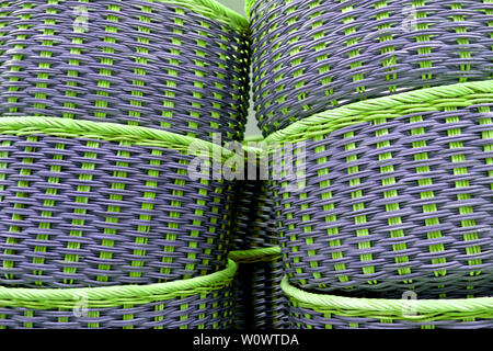 Stack of vibrant green and purple colored wicker baskets Stock Photo