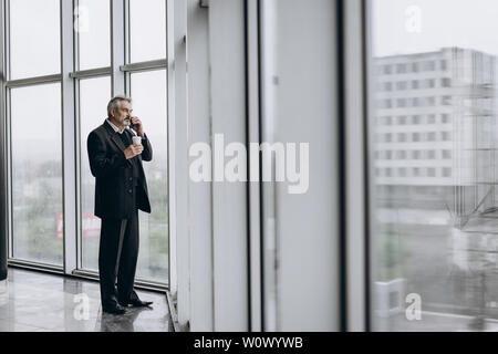 Serious elder man in big office centre Stock Photo