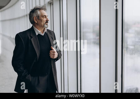 Serious elder man in big office centre Stock Photo