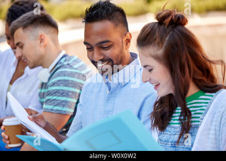 group of happy students with notebooks outdoors Stock Photo