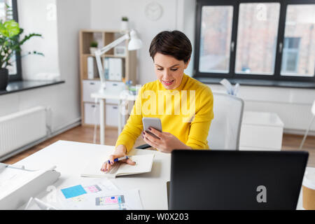 smiling ui designer using smartphone at office Stock Photo