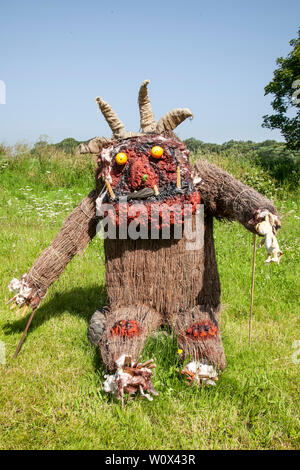 Halsall, Lancashire. 28th June 2019. UK Weather.  Sunny summer sculptures appear over night. Grotesque, quirky, straw filled scarecrows, film characters, caricatures with scary masked faces, line the streets & fields of the rural village of Halsall. Credit: MWI/AlamyLiveNews Stock Photo