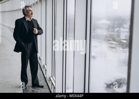 Serious elder man in big office centre Stock Photo