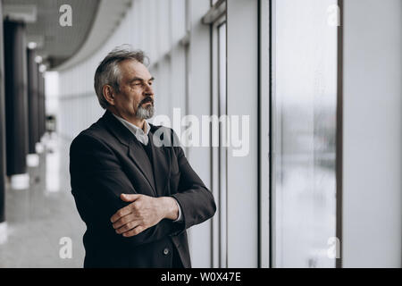Serious elder man in big office centre Stock Photo