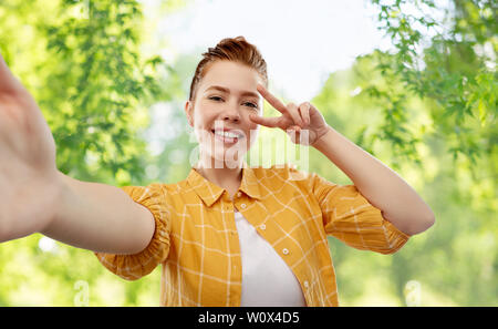 redhead teenage girl taking selfie making peace Stock Photo