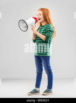 smiling red haired girl speaking to megaphone Stock Photo