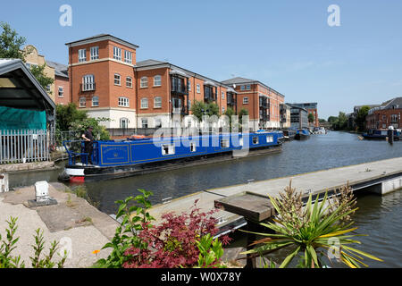 Diglis, Worcester, UK - June 2019 - A canal boat passes through Diglis Basin in Worcester passing the modern residential flats on a hot sunny day. The Worcester & Birmingham Canal joins the River Severn at Worcester. Photo Steven May / Alamy Live News Stock Photo