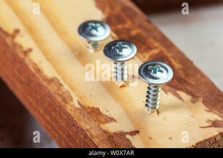 screw screwed into a wooden bar Stock Photo
