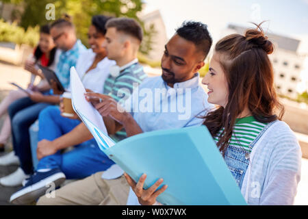 group of happy students with notebooks outdoors Stock Photo