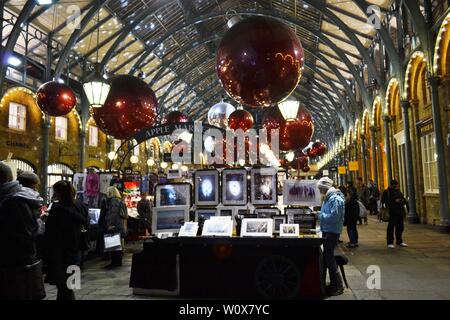 London/UK - November 27, 2013: People shopping at the Covent Garden Apple market decorated for Christmas holidays. Stock Photo