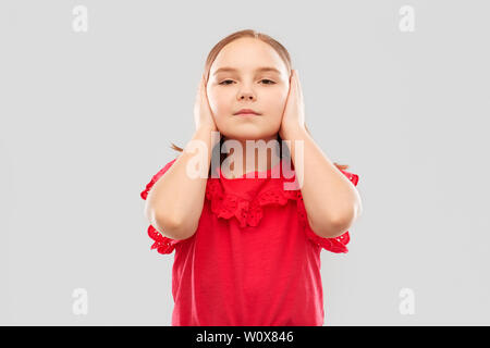 beautiful girl in red shirt closing ears by hands Stock Photo