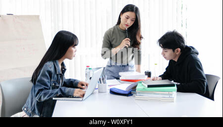Group Students Smile and have fun and using tablet It also helps to share ideas in the work and project. And also review the book before the exam Stock Photo