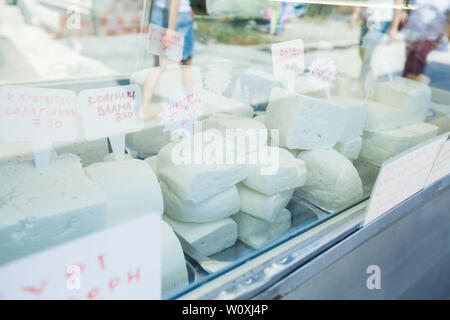 Assortment of homemade cow cheese on local farmers market stall on Greece marketplace. Stock Photo